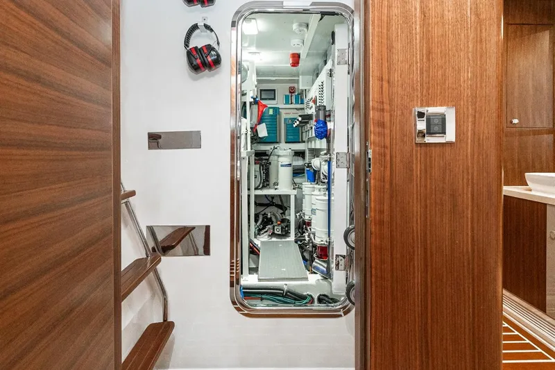 Valencia Yacht Photos Pics Engine room of a 2019 Belize 66 Sedan yacht with wooden interior and equipment.
