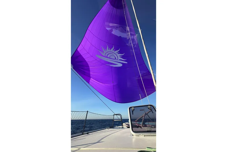 Gtfo Yacht Photos Pics Purple sail on Balance 482 yacht, 2023 model, against clear blue sky.