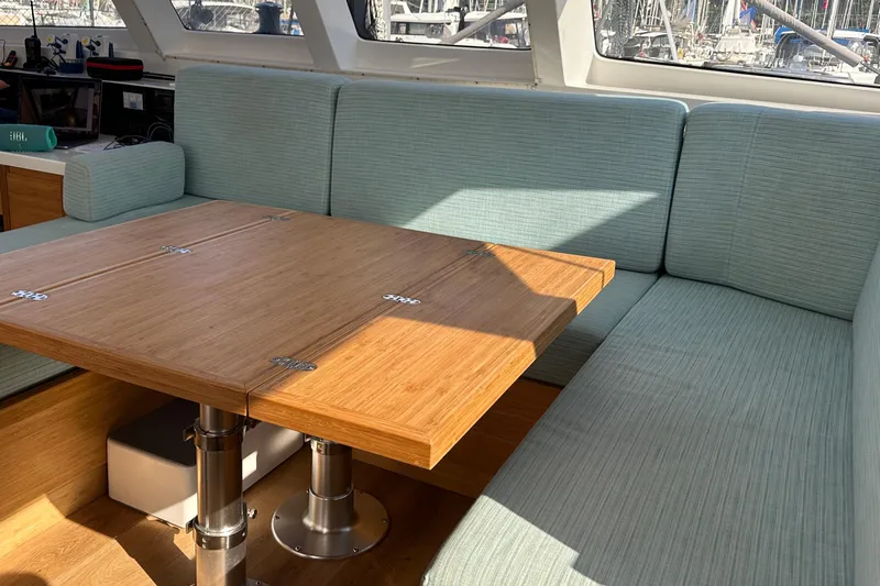 Gtfo Yacht Photos Pics Modern interior of Balance 482 yacht, featuring a wooden table and cushioned seating, 2023 model.