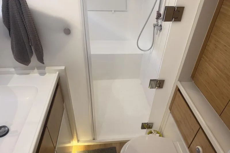 Gtfo Yacht Photos Pics Modern bathroom with shower, wooden cabinets, and towel, in a 2023 Balance 482 model.