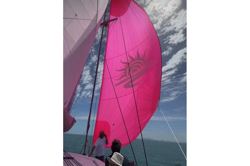 Gtfo Yacht Photos Pics Sailboat with vibrant pink sail, Balance 482 model, 2023, under a partly cloudy sky.