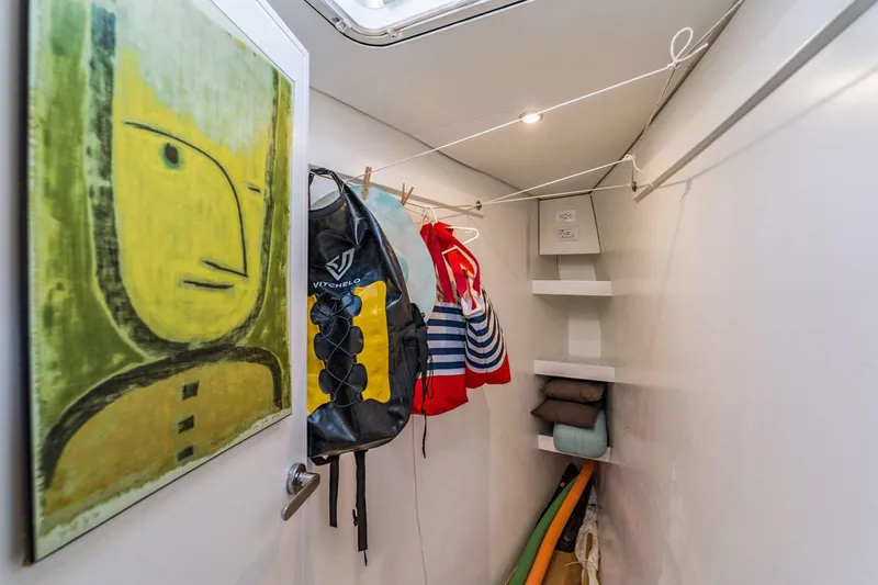 Gtfo Yacht Photos Pics Laundry room in Balance 482 yacht, featuring artwork, hanging clothes, and storage shelves.