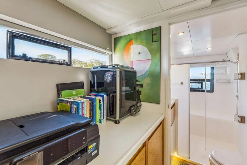 Gtfo Yacht Photos Pics Modern interior of Balance 482 yacht, featuring books, printer, and abstract art.