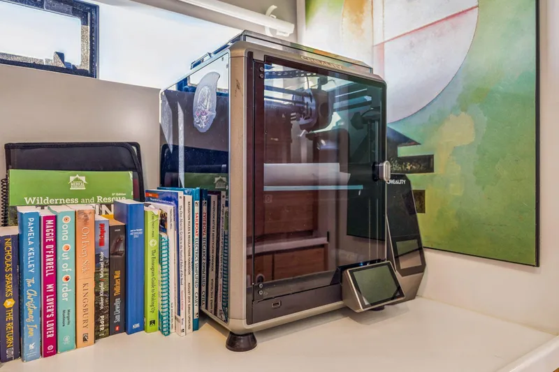 Gtfo Yacht Photos Pics 3D printer Balance 482 (2024) beside colorful books on a shelf.