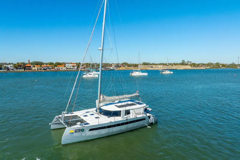 Gtfo Yacht Photos Pics 2024 Balance 482 catamaran sailing in a calm bay with clear blue skies.