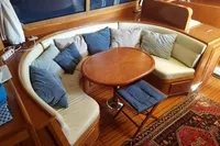 Luxurious 2001 Trader 535 Signature yacht interior with curved seating and wooden table.