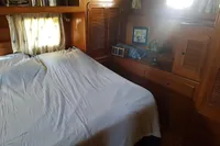 Cozy cabin interior of 2001 Trader 535 Signature yacht with bed and wooden furnishings.