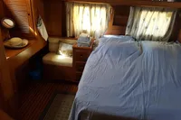 Cozy cabin interior of 2001 Trader 535 Signature yacht with bed and wooden furnishings.