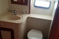 2001 Trader 535 Signature yacht bathroom with sink, toilet, and porthole window.