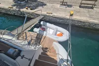 Docked Trader 535 Signature yacht with inflatable dinghy, 2001 model, in clear blue water.