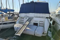 Trader 535 Signature yacht, 2001 model, docked with dinghy and boarding ramp.