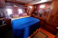Luxurious cabin interior of 2001 Trader 535 Signature yacht with cozy bed and wooden furnishings.
