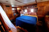 Luxurious cabin interior of 2001 Trader 535 Signature yacht with wooden furnishings and cozy bedding.