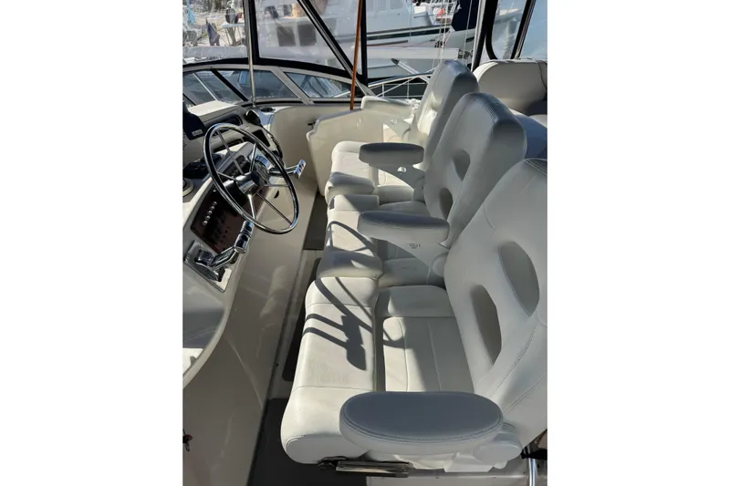  Yacht Photos Pics 2005 Silverton 43 Motor Yacht helm with white leather seats and steering wheel.