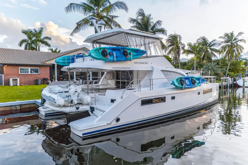 Southern Sky Yacht Photos Pics 2018 Leopard 51 Powercat yacht docked, featuring kayaks and palm trees in the background.