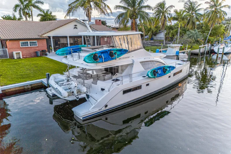 Southern Sky Yacht Photos Pics 2018 Leopard 51 Powercat docked by a house with kayaks on deck.