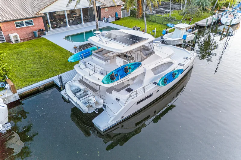 Southern Sky Yacht Photos Pics 2018 Leopard 51 Powercat docked by a house with pool and kayaks on deck.