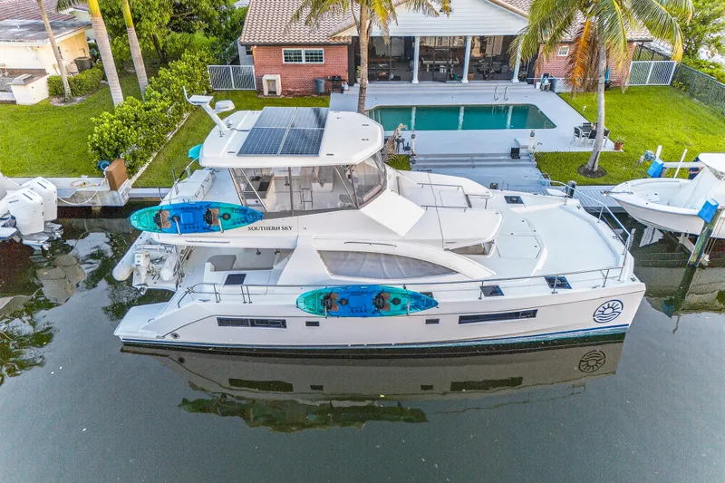 Southern Sky Yacht Photos Pics 2018 Leopard 51 Powercat docked by a poolside home, featuring kayaks and solar panels.