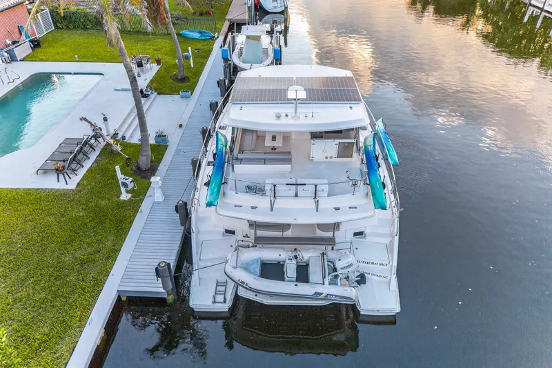 Southern Sky Yacht Photos Pics 2018 Leopard 51 Powercat docked by a poolside with lush greenery.