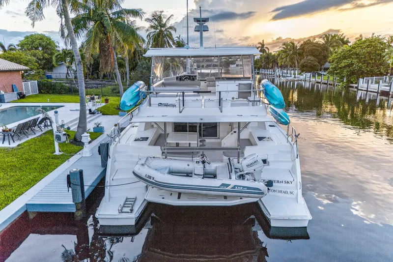 Southern Sky Yacht Photos Pics 2018 Leopard 51 Powercat yacht docked by a tropical waterfront at sunset.