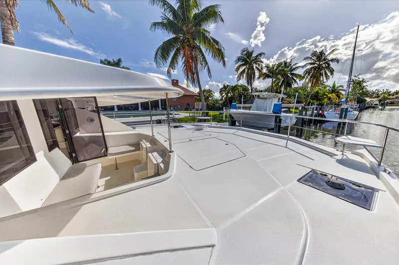Southern Sky Yacht Photos Pics 2018 Leopard 51 Powercat yacht docked, featuring spacious deck and tropical palm trees.