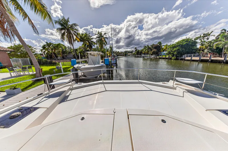 Southern Sky Yacht Photos Pics 2018 Leopard 51 Powercat docked by a scenic canal with palm trees and blue sky.