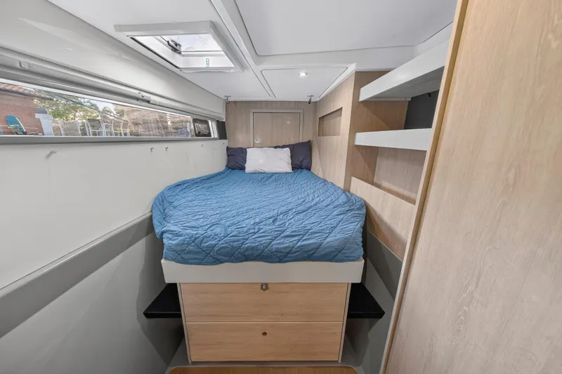 Southern Sky Yacht Photos Pics Cozy bedroom in 2018 Leopard 51 Powercat with blue bedding and wooden storage.
