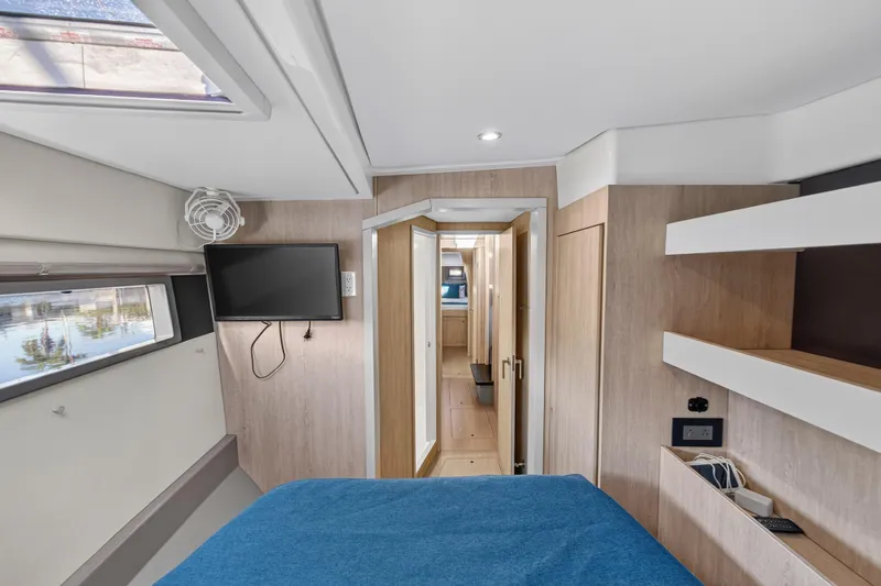 Southern Sky Yacht Photos Pics Interior of 2018 Leopard 51 Powercat cabin with modern design, TV, and blue bedding.