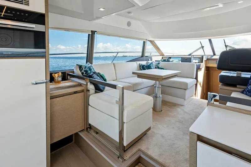 Jilligans Island Yacht Photos Pics Luxurious interior of 2023 Prestige 460 Flybridge yacht with elegant seating and ocean view.