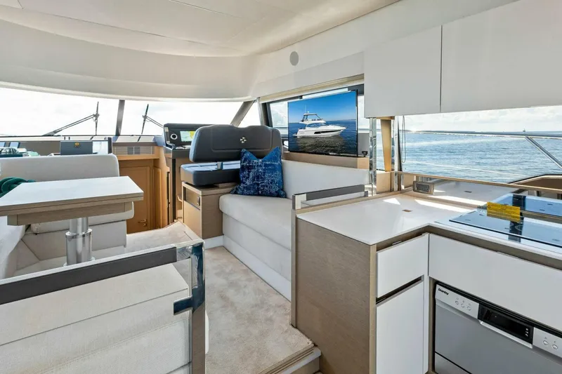 Jilligans Island Yacht Photos Pics Luxurious interior of 2023 Prestige 460 Flybridge yacht with modern kitchen and seating area.