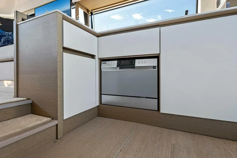 Jilligans Island Yacht Photos Pics Modern kitchen area in 2023 Prestige 460 Flybridge yacht, featuring sleek cabinetry and built-in appliances.