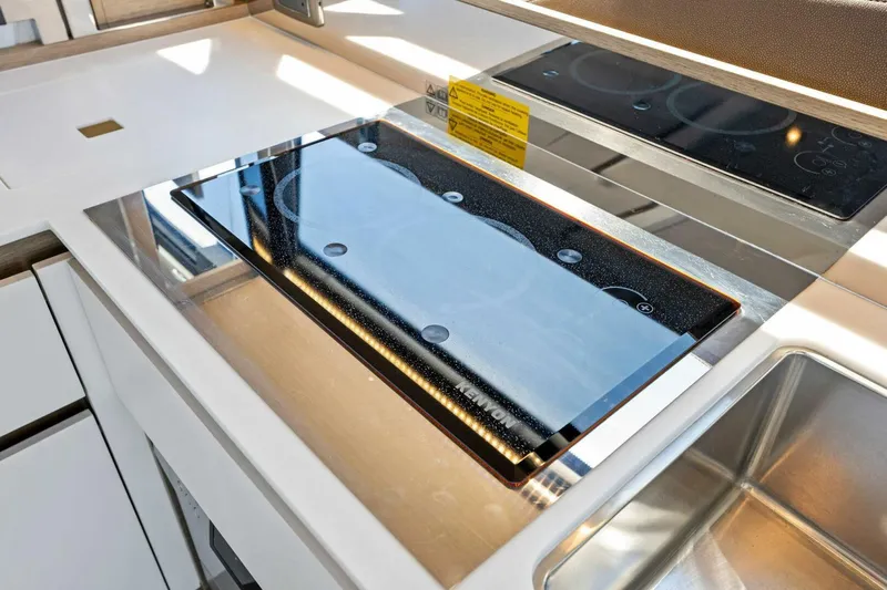 Jilligans Island Yacht Photos Pics Modern kitchen on 2023 Prestige 460 Flybridge yacht with sleek stovetop and sink.