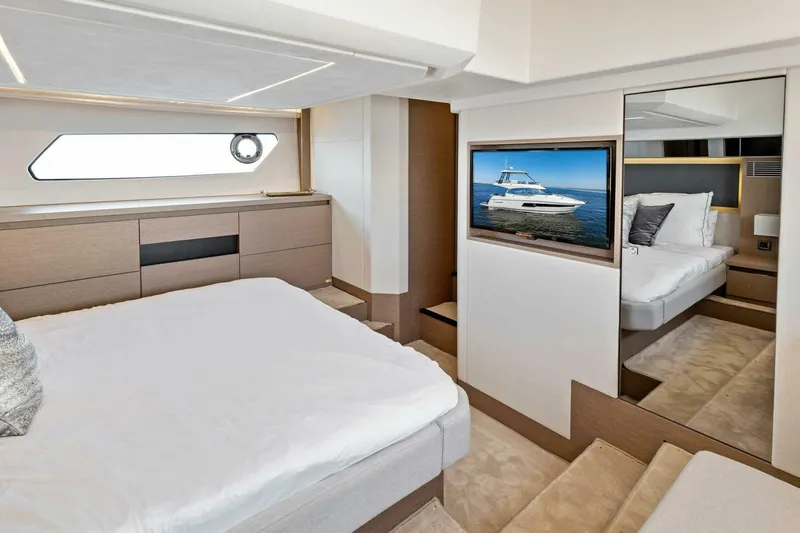 Jilligans Island Yacht Photos Pics Luxurious bedroom interior of 2023 Prestige 460 Flybridge yacht with modern design and TV.