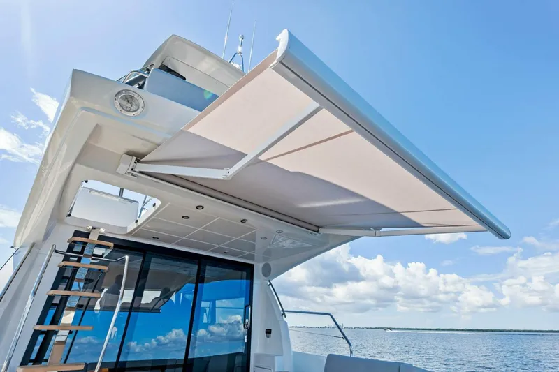 Jilligans Island Yacht Photos Pics Prestige 460 Flybridge 2023 yacht with extended sunshade on a sunny day.