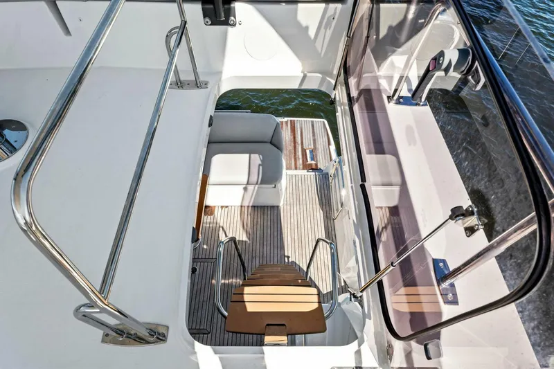 Jilligans Island Yacht Photos Pics Prestige 460 Flybridge 2023 yacht interior with wooden stairs and seating area.