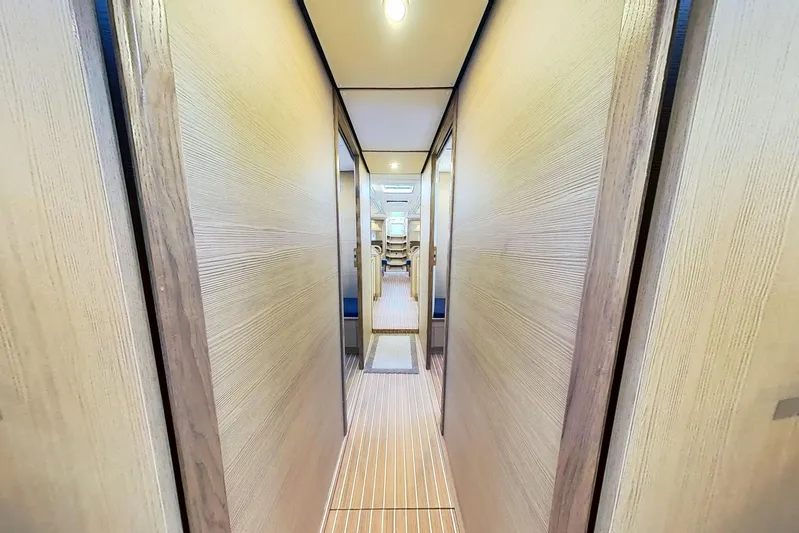 Sea Wave Yacht Photos Pics Narrow hallway inside 2024 Kufner 54 yacht, featuring wooden paneling and modern lighting.