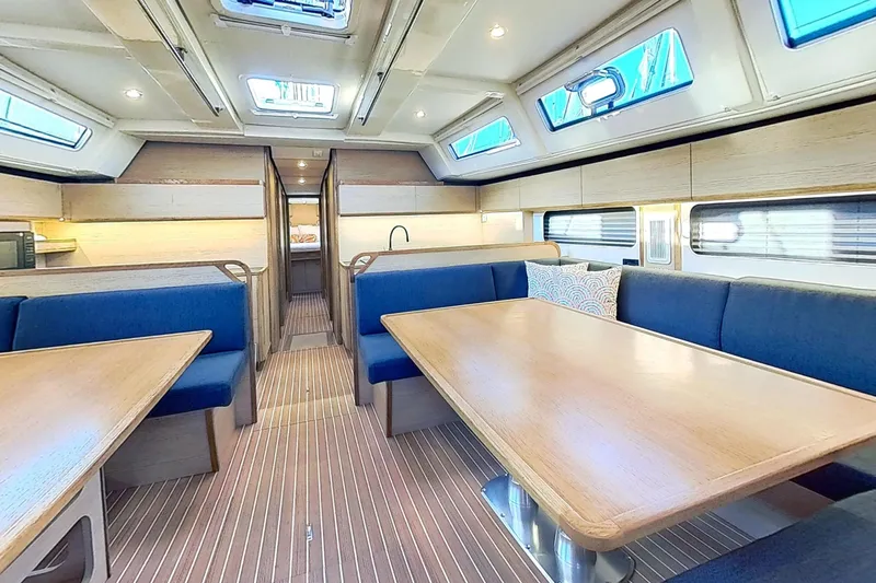Sea Wave Yacht Photos Pics Interior of 2024 Kufner 54 yacht with modern seating and wooden tables.
