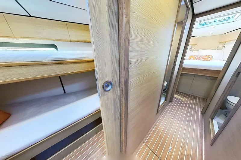Sea Wave Yacht Photos Pics 2024 Kufner 54 yacht interior with wooden finish, featuring bunk beds and a cozy cabin.