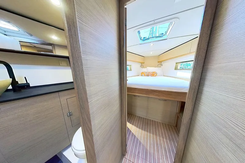 Sea Wave Yacht Photos Pics Luxurious interior of 2024 Kufner 54 yacht featuring a cozy bedroom and modern bathroom.