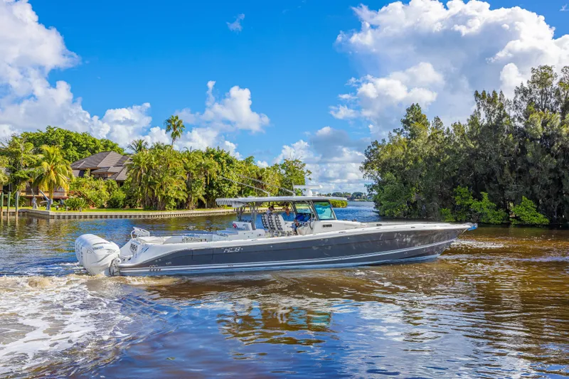 2022 425 Yamahas Yacht Photos Pics 2019 HCB 53 Sue&ntilde;os boat cruising on a scenic river with lush greenery.