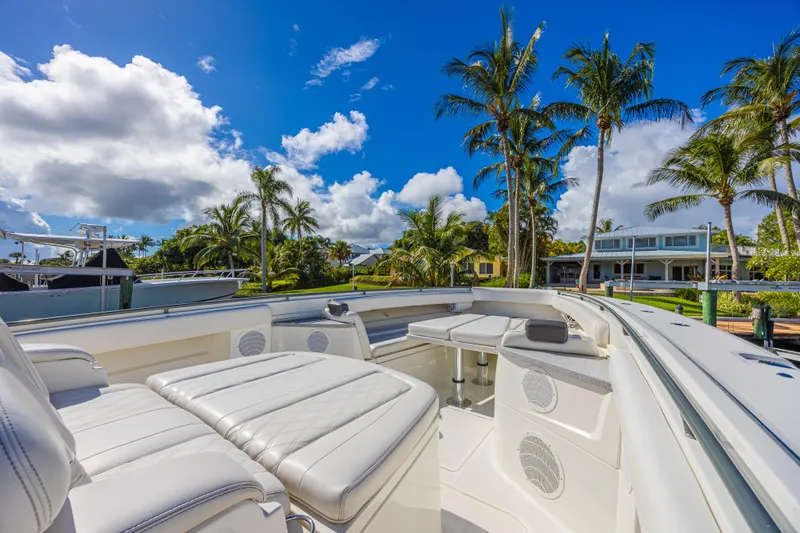 2022 425 Yamahas Yacht Photos Pics Luxurious 2019 HCB 53 Sue&ntilde;os boat interior with plush seating, palm trees, and blue sky backdrop.