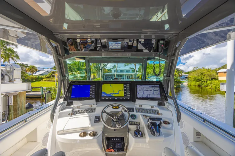 2022 425 Yamahas Yacht Photos Pics Cockpit of 2019 HCB 53 Sue&ntilde;os boat with advanced navigation systems and scenic waterway view.