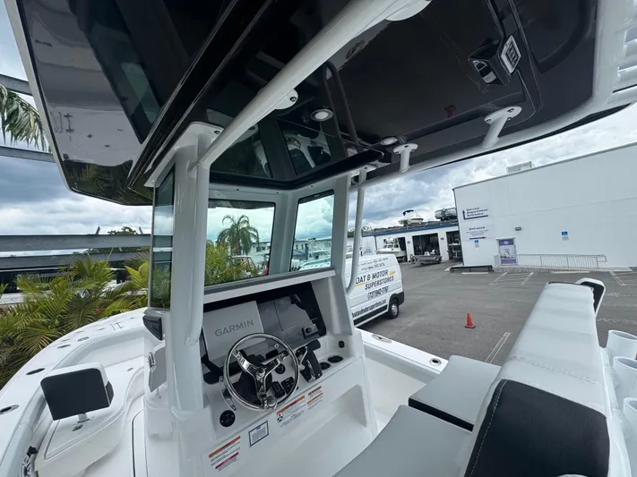  Yacht Photos Pics 2026 Blackfin 262 HB boat cockpit with Garmin navigation, docked near a white building.