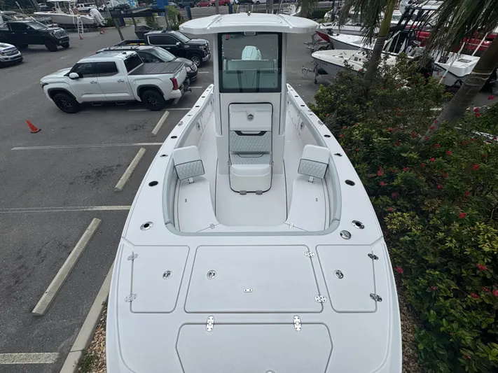  Yacht Photos Pics 2026 Blackfin 262 HB boat in parking lot, surrounded by vehicles and greenery.