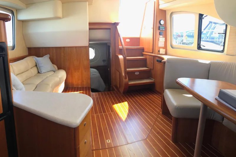 Joie De Vivre Yacht Photos Pics Interior of 2003 Silverton 35 Motor Yacht with wood flooring and cozy seating area.