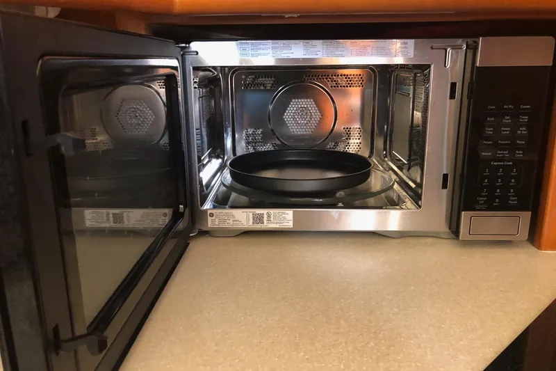 Joie De Vivre Yacht Photos Pics Open microwave oven on a 2003 Silverton 35 Motor Yacht kitchen counter.