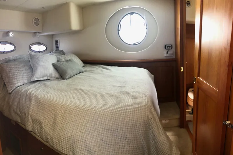 Joie De Vivre Yacht Photos Pics 2003 Silverton 35 Motor Yacht bedroom with cozy bedding and porthole window.
