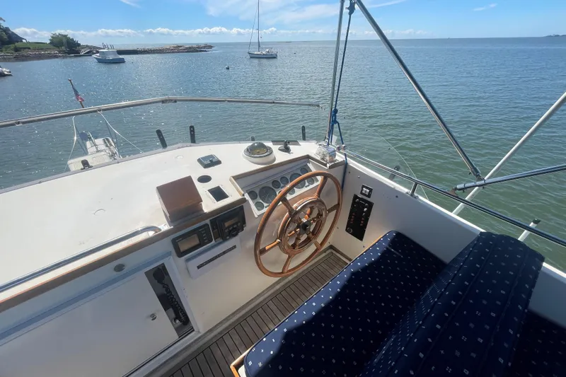 Island Girl Yacht Photos Pics 1990 Grand Banks 46 Classic yacht helm with wooden wheel, overlooking serene waters.