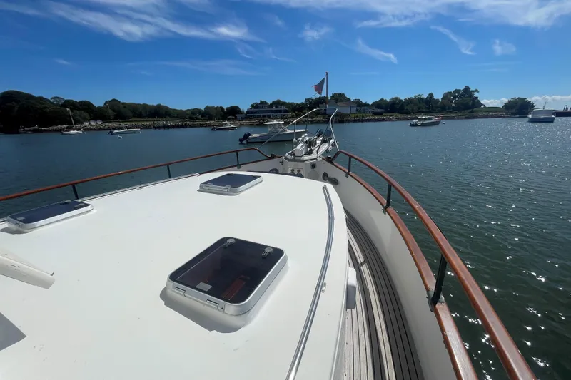 Island Girl Yacht Photos Pics 1990 Grand Banks 46 Classic yacht on calm water under clear blue sky.