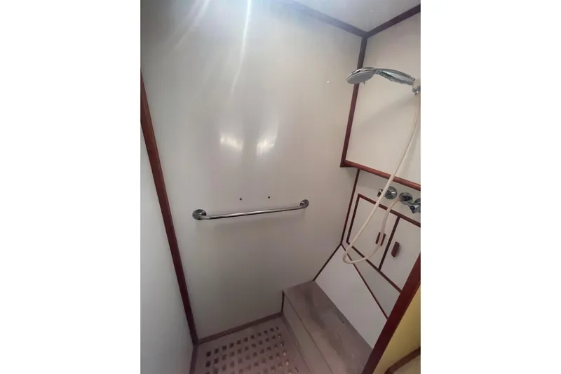 Island Girl Yacht Photos Pics Shower area in 1990 Grand Banks 46 Classic yacht, featuring a handheld showerhead and grab bar.